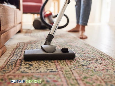 امرأة تنظف الأرضية بمكنسة كهربائية خفيفة الوزن