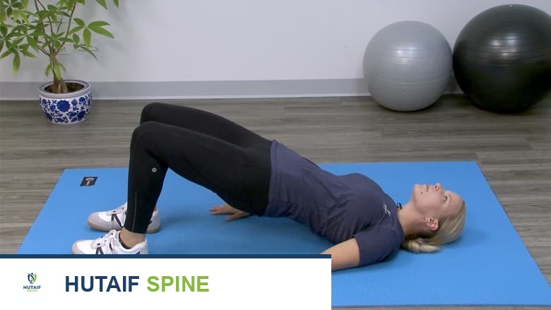 Therapist showing bridge exercise.