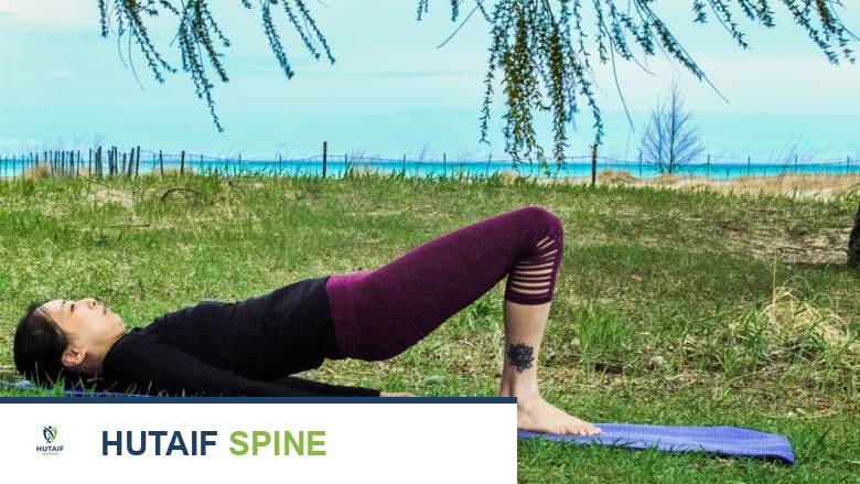 امرأة مستلقية على ظهرها في الهواء الطلق تؤدي تمرين الجسر