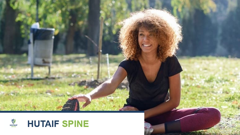 امرأة تقوم بتمارين تمدد في الحديقة