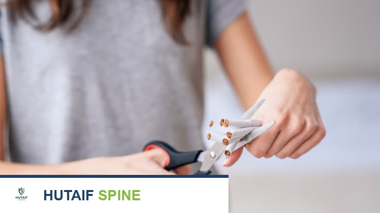 امرأة تقطع السجائر كرمز للإقلاع عن التدخين وتخفيف آلام الظهر